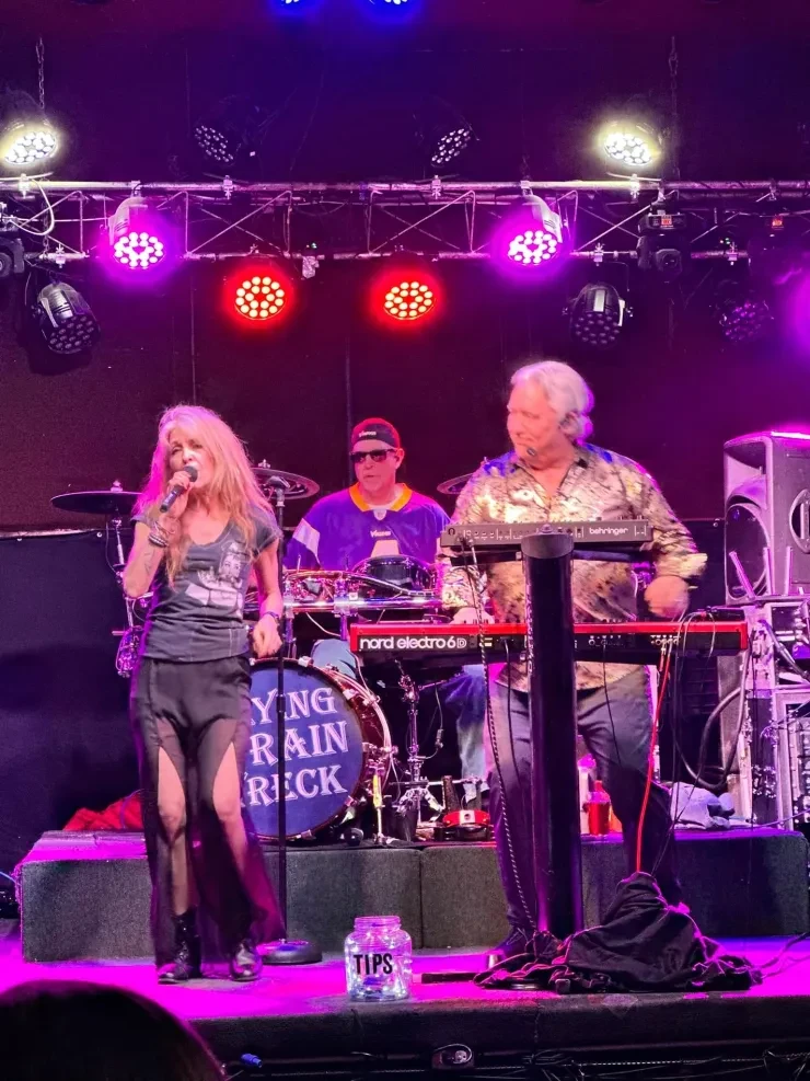 Baibi singing with Matt on drums and Loren on keys – pink stage lighting