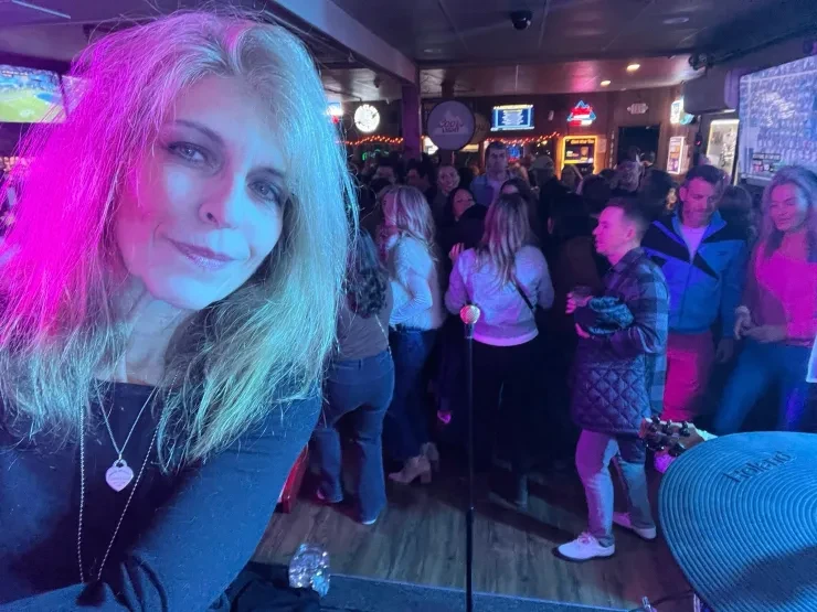 Baibi selfie with packed dance floor behind her – pink and purple lighting