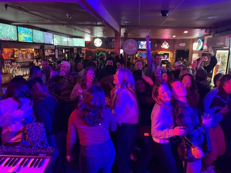 Crowd dancing at a Flying Train Wreck show – purple and blue lighting