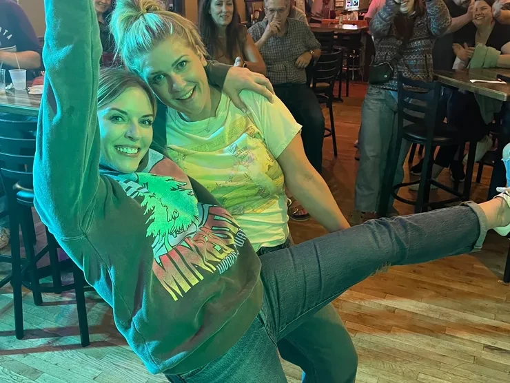 Two fans dancing and having a blast at a Flying Train Wreck show – green lighting