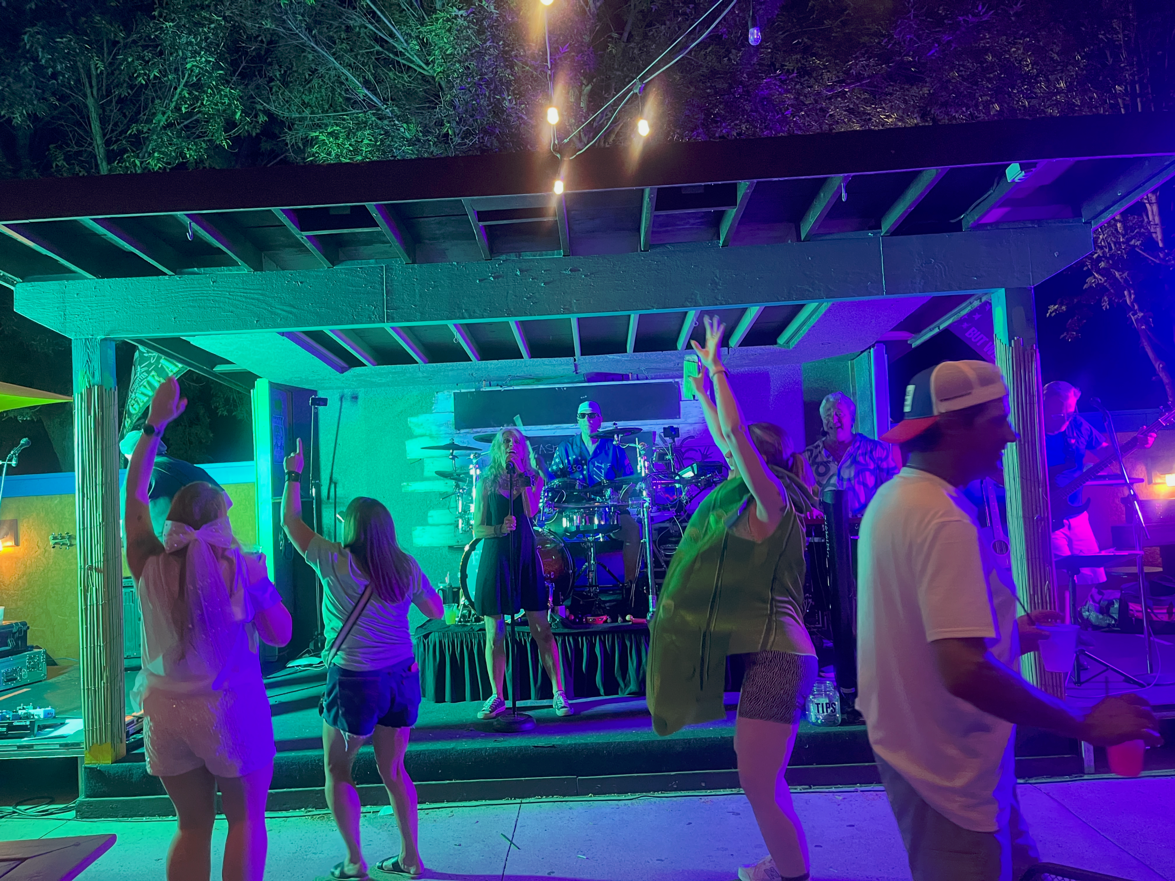 Crowd dancing at Flying Train Wreck show – neon cyan lighting