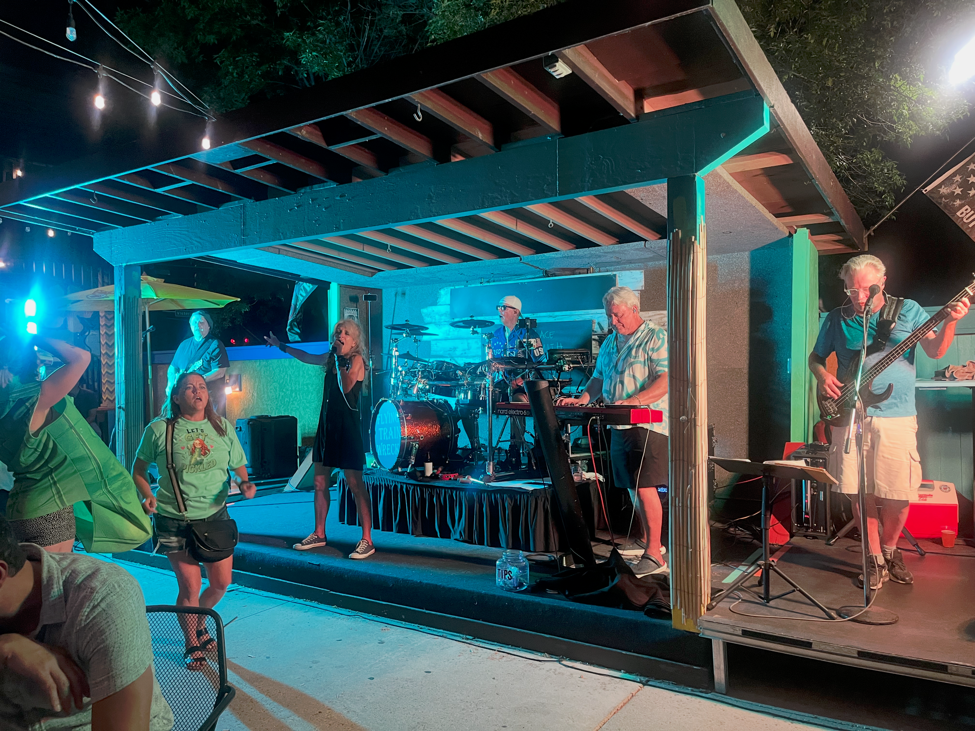 Flying Train Wreck full band performing – teal lighting