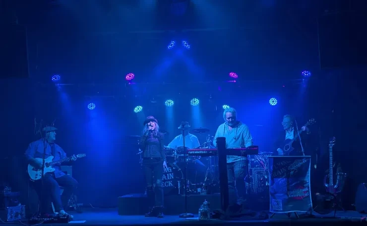 Flying Train Wreck full band on stage under dramatic blue stage lighting