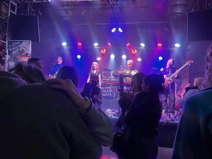 Flying Train Wreck full band on stage viewed from the crowd – purple and blue lighting