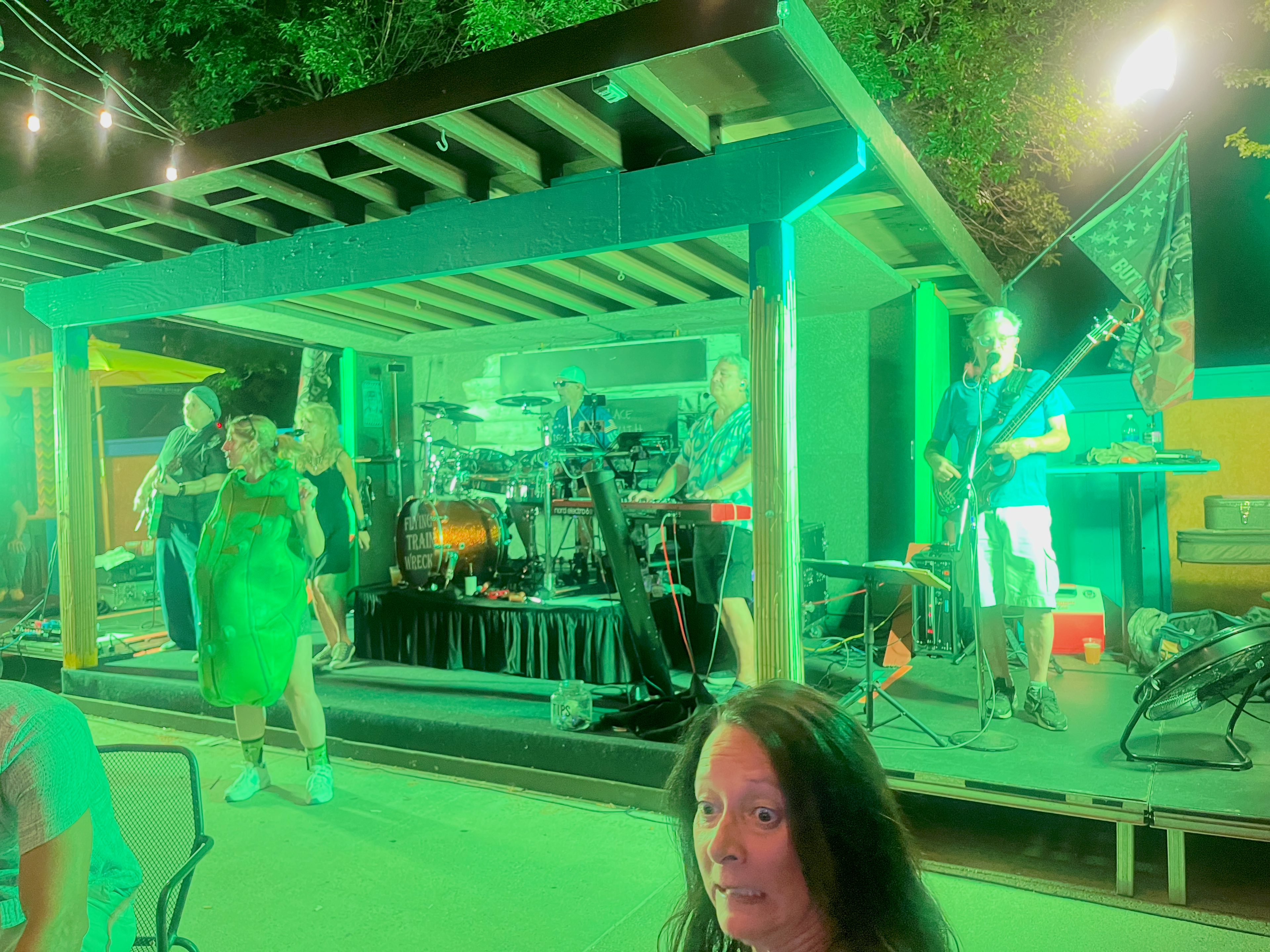 Flying Train Wreck outdoor stage – green lighting, drum kit visible