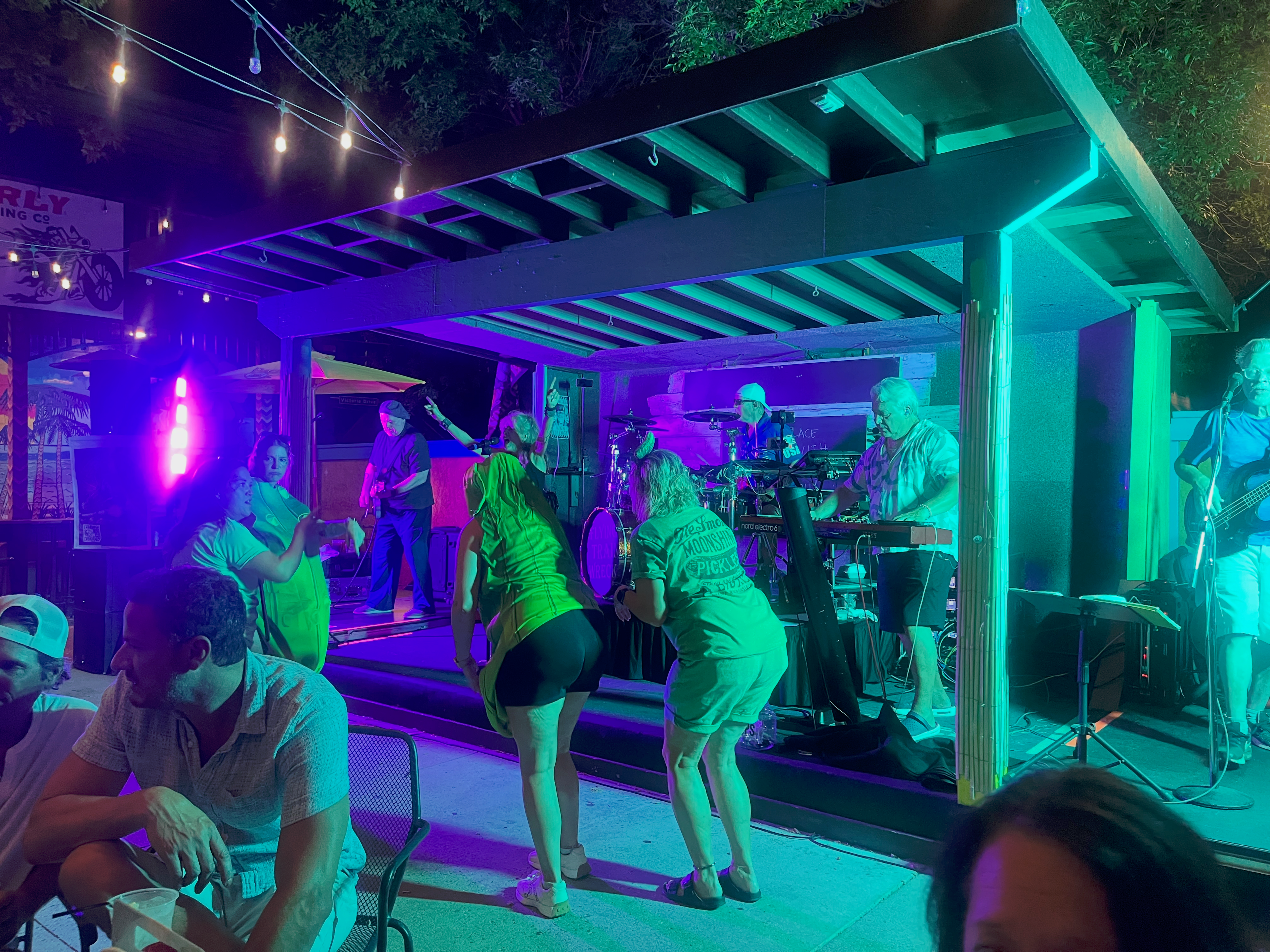 Flying Train Wreck outdoor stage – teal lighting with dancers