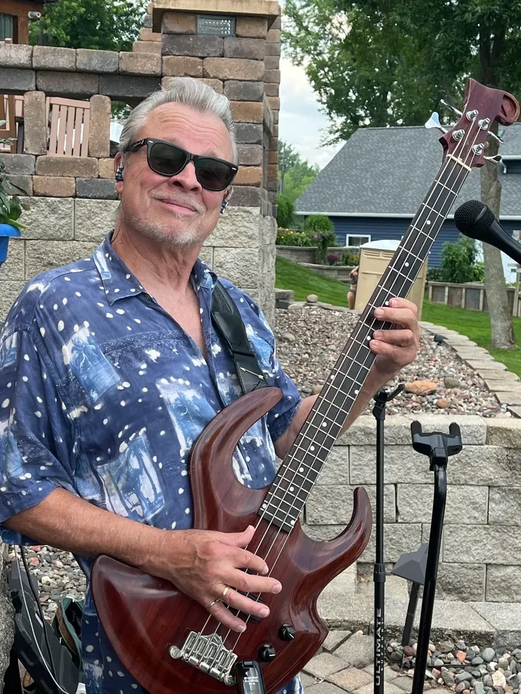 Rick holding his bass guitar at an outdoor private party show