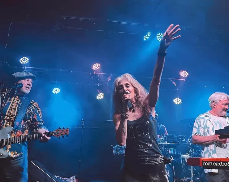 Flying Train Wreck vocalist with hand raised – blue stage lighting